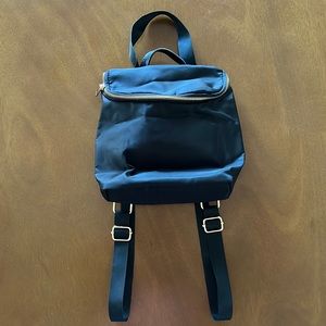 Black mini backpack with adjustable straps, interior pockets.